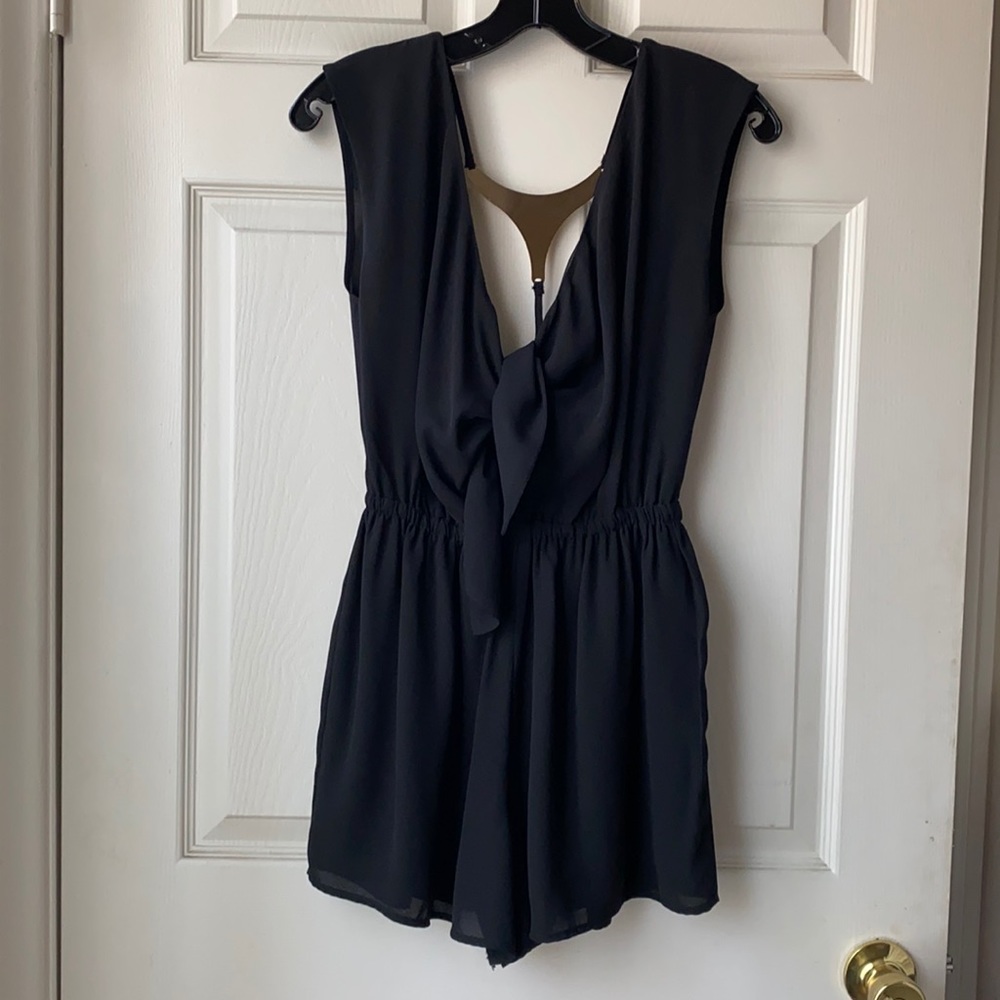 Black romper with metal detail on back.